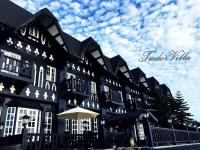 a black building with white windows and an umbrella at Tudor Dynasty Homestay in Yanliau