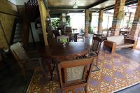 een eetkamer met een houten tafel en stoelen bij Katumbiri Resort in Bogor