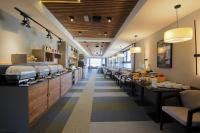 un restaurante con una larga fila de mostradores y mesas en Lumière Hotel Pool & SPA, en Belgrado