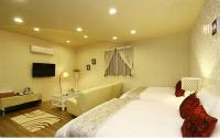 a hotel room with a large bed and a television at Maple in Wujie