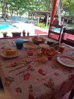 a table with plates of food and utensils on it at Pousada ZEN Cumuruxatiba in Cumuruxatiba