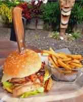 a sandwich and a basket of french fries on a table at Tiki Lodge Hotel de Charme in Santa Catalina