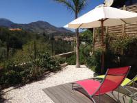 a patio with a chair and an umbrella at Villa Bougainvilliers in Banyuls-sur-Mer