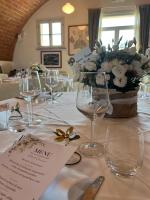 a table with wine glasses and a vase of flowers at Le Sodole Country Resort & Golf in Pontedera