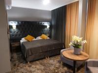 Un dormitorio con una cama, una mesa y un sofá. en Hotel Mieszko, en Gorzów Wielkopolski