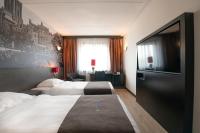 Una habitación de hotel con dos camas y un televisor de pantalla plana. en Bastion Hotel Utrecht, en Utrecht