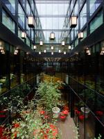 a large glass building with potted plants in it at citizenM Southwark Bankside in London