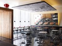 a room with tables and chairs and a staircase at citizenM Southwark Bankside in London