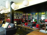 a lobby of a restaurant with couches and a bar at citizenM Southwark Bankside in London