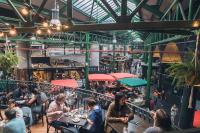 a group of people sitting at tables in a restaurant at citizenM Southwark Bankside in London