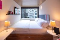 a bedroom with a large bed with two lamps at citizenM Southwark Bankside in London