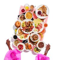 a table full of plates of food with people at citizenM Southwark Bankside in London