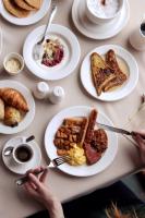 a table with plates of breakfast food on it at Gîte du Mont-Albert - Sepaq in Sainte-Anne-des-Monts