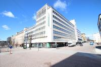 a large white building on a city street at Forenom Aparthotel Lahti in Lahti