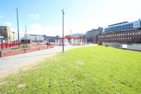 a large field of grass in a city with buildings at Forenom Aparthotel Lahti in Lahti