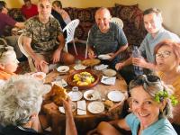 Un grupo de personas sentadas alrededor de una mesa comiendo comida en Ryad-IGRANE, en Ouarzazate