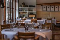 Un restaurante con mesas y sillas con manteles blancos. en Norsminde Kro, en Odder