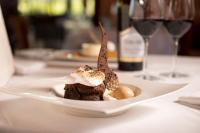 een bord met een dessert op een tafel met wijnglazen bij Vinarosa Resort & Spa in Santa Rosa