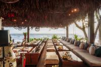 a restaurant on the beach with tables and chairs at Café del Mar Phuket - Suite & Penthouse in Kamala Beach