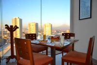 comedor con mesa y vistas a la ciudad en La Quinta by Wyndham Puebla Palmas Angelopolis, en Puebla