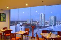 Un restaurante con mesas y sillas y un gran ventanal. en La Quinta by Wyndham Puebla Palmas Angelopolis, en Puebla