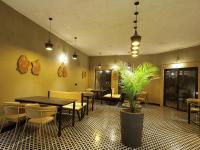 um restaurante com mesas e cadeiras e uma planta em vaso em Meladin Sariska em Tehla