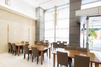 uma sala de jantar com mesas e cadeiras de madeira em Hotel Centmain Nagoya em Nagoya