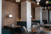 a dining room with tables and chairs and lights at Хотел Crystal in Ruse