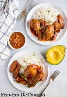 サンペドロ・デ・マコリスにある1st Line viewのテーブルの上にはご飯と肉が載った3枚の皿がある