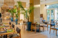 a restaurant with tables and chairs and plants at Holiday Inn - Lusaka by IHG in Lusaka