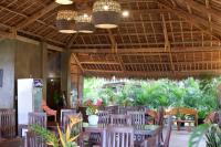 Un comedor con mesas y sillas y plantas. en Solaj Dive and Beach Resort Zamboanguita, en Zamboanguita