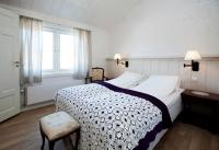 レーロースにあるErzscheidergaarden Hotellの大きなベッドと窓のある寝室