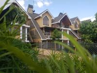 a large house with green plants in front of it at Asyana Gardens in Nairobi