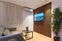 ein Wohnzimmer mit einem Sofa und einem Fernseher an der Wand in der Unterkunft סוויטות אוראל 432 in Eilat