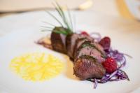 un plato de comida con carne y fruta en una mesa en Hotel Cant del Gal, en Fiera di Primiero