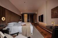 a hotel room with a large bed with white pillows at Rong Unique Hotel-Banyan Lake Scenery in Guilin