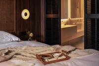 a tray of food and a glass of wine on a bed at Rong Unique Hotel-Banyan Lake Scenery in Guilin
