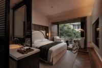 a bedroom with a bed and a sink and a mirror at Rong Unique Hotel-Banyan Lake Scenery in Guilin
