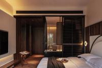 a bedroom with a bed with a table in it at Rong Unique Hotel-Banyan Lake Scenery in Guilin