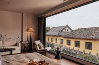 a bedroom with a large window with a view of a building at Rong Unique Hotel-Banyan Lake Scenery in Guilin