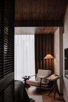 a living room with a chair and a lamp at Rong Unique Hotel-Banyan Lake Scenery in Guilin