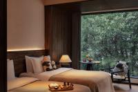 two beds in a room with a large window at Rong Unique Hotel-Banyan Lake Scenery in Guilin
