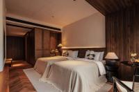 a hotel room with two beds with white sheets at Rong Unique Hotel-Banyan Lake Scenery in Guilin