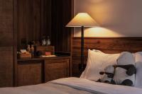 a teddy bear sitting on a pillow on a bed at Rong Unique Hotel-Banyan Lake Scenery in Guilin