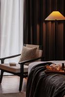 a bedroom with a bed and a chair and a lamp at Rong Unique Hotel-Banyan Lake Scenery in Guilin