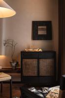 a black cabinet in a living room with a vase at Rong Unique Hotel-Banyan Lake Scenery in Guilin