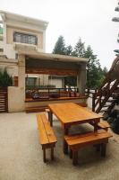 a picnic table and benches in front of a building at Sabai B&amp;B 澎湖船家寶民宿 in Huxi