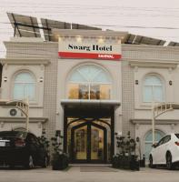 un hotel inteligente con coches estacionados frente a él en Swarg Hotel, en Sāhīwāl
