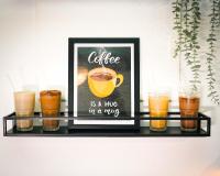 Un estante con la imagen de un café es un abrazo en una taza. en Paprika Stays Panjim Donapaula, en Panaji