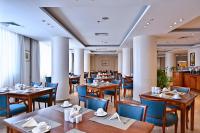 Un restaurante con mesas de madera y sillas azules. en Swiss Inn Nile Hotel, en El Cairo